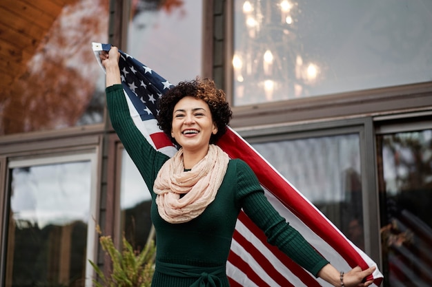 Mujer orgullosa de tiro medio con bandera