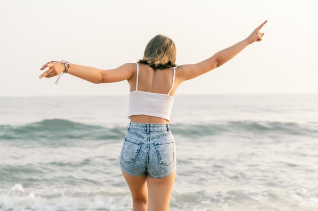 Mujer en la orilla de la playa desde atrás