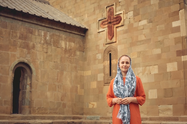 Mujer ortodoxa por una antigua iglesia cristiana.