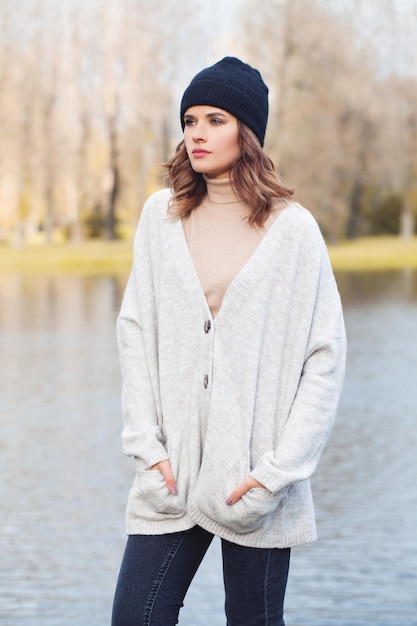 Mujer de otoño con gorra negra al aire libre en el parque de otoño