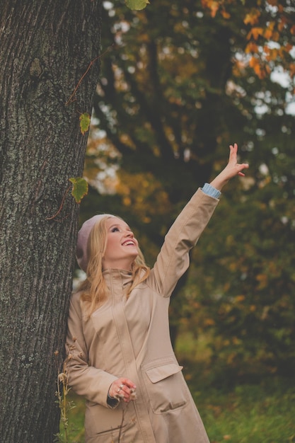 Mujer de otoño saludando al aire libre en el parque de otoño