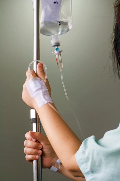 Mujer paciente en el hospital con solución salina intravenosa iv