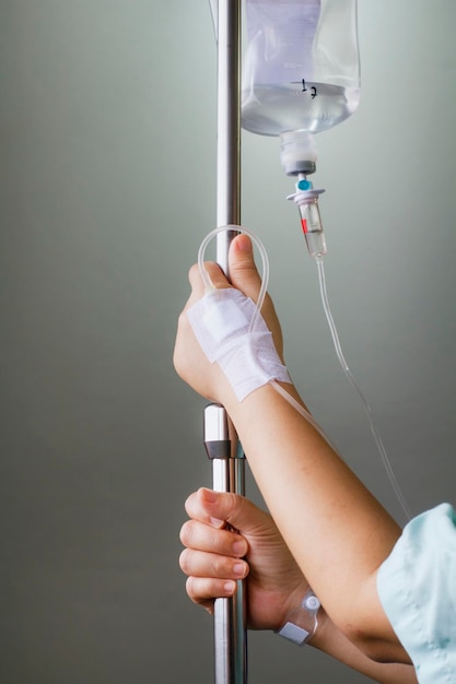 Mujer paciente en el hospital con solución salina intravenosa iv