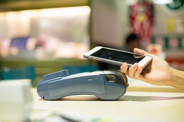 Mujer paga por teléfono celular en el restaurante