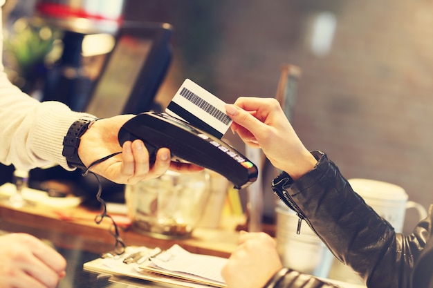 Mujer pagando con tarjeta de crédito en restaurante.