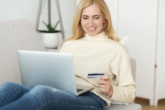 Mujer de pago en línea comprando ropa en línea en la computadora portátil