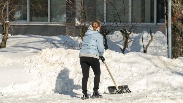 una mujer paleando nieve