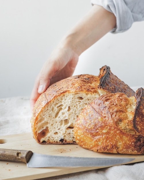 Mujer panadera cocina pan en la cocina una cocinera en una pastelería tiene pan en sus manos