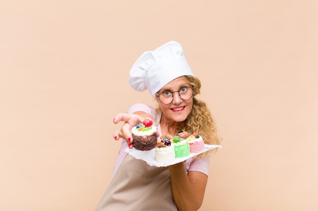 Foto mujer panadera de mediana edad cocinando pasteles