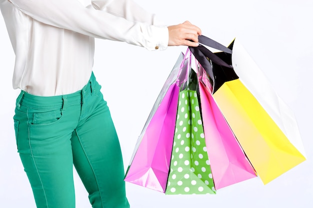 mujer en pantalones verdes con bolsa de compras