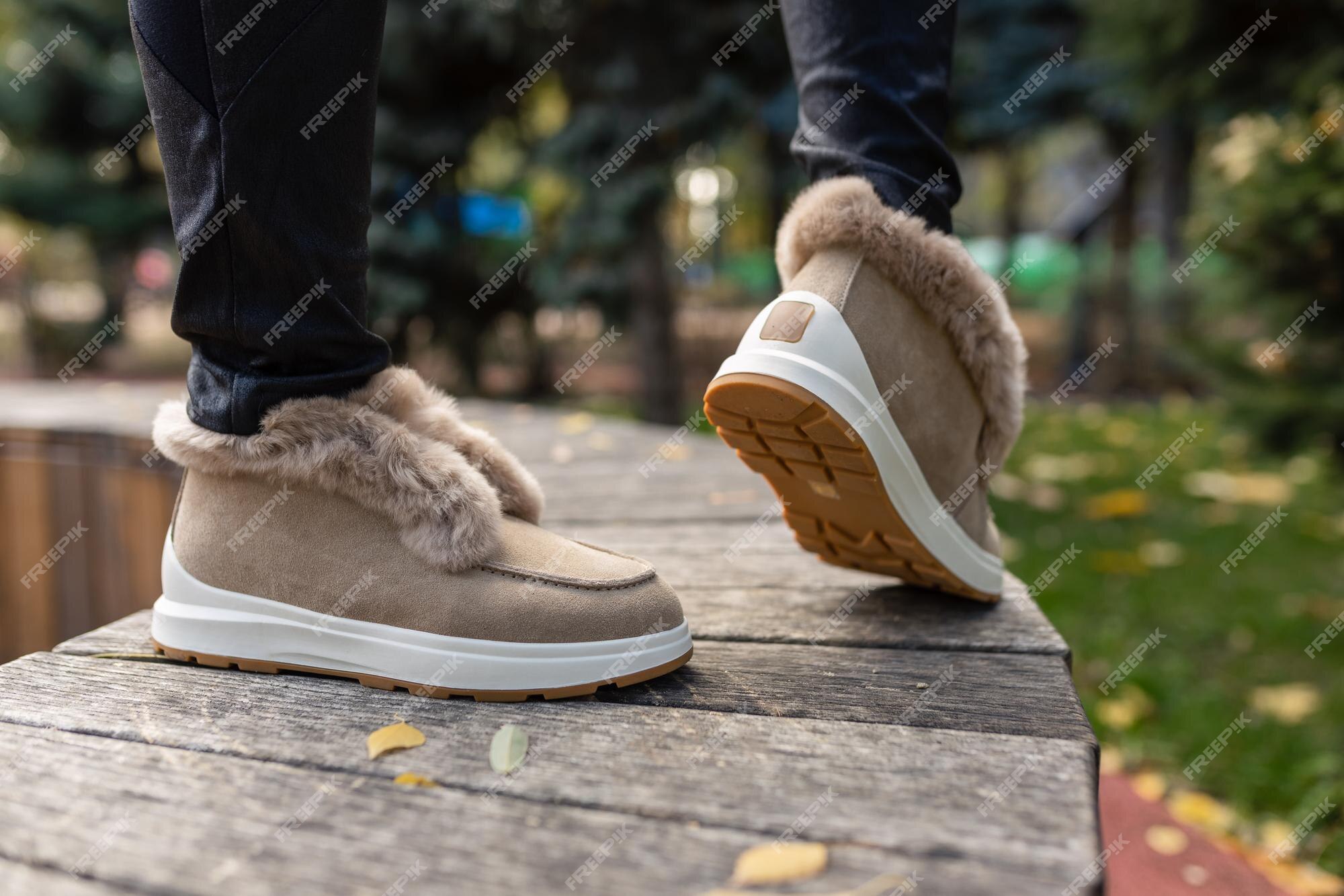 Una mujer con un par de botas que dicen 'ugg' en el lateral. Foto Premium