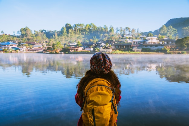 La mujer parada cerca del lago