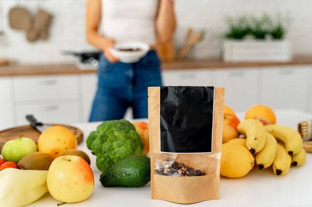 Foto mujer parada en la cocina junto a un mostrador lleno de frutas y verduras una foto de una mujer parada en una cocina junto a un mostrador lleno de abundantes frutas y verduras frescas