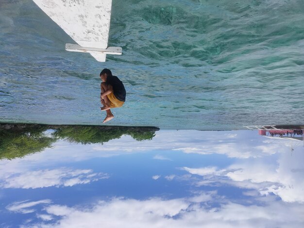 Foto mujer con paraguas en la orilla del mar