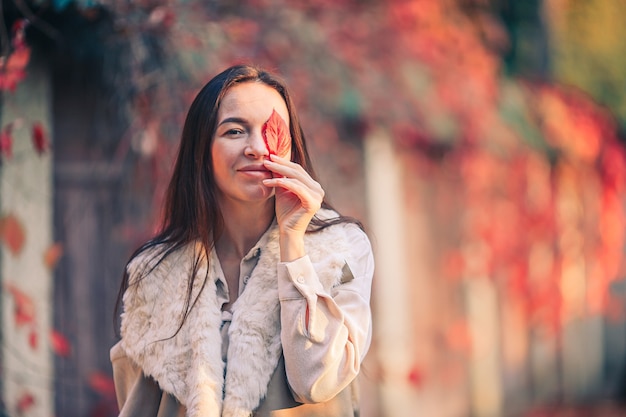 Mujer en el parque de otoño bajo el follaje de otoño