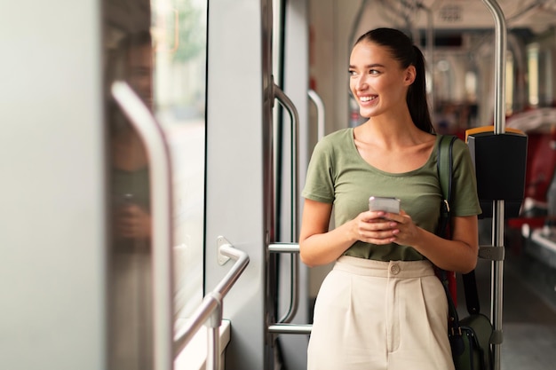 Mujer pasajera navegando por teléfono en el tranvía interior