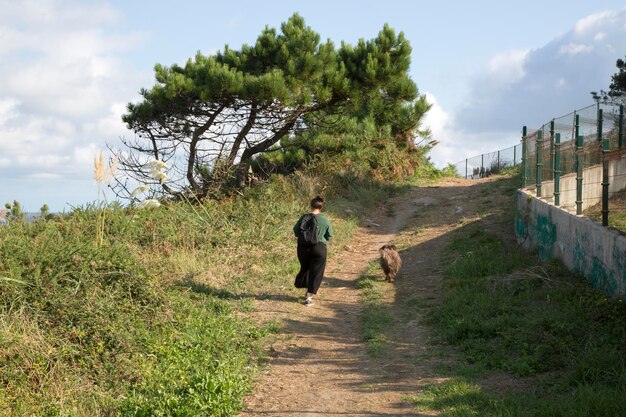 Mujer paseando a un perro en Loredo, Santander, España