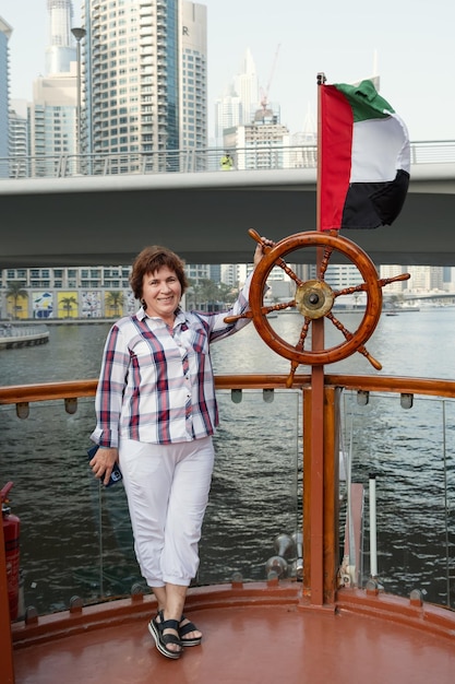 Mujer en un paseo en barco en la marina de Dubai Mujer turista jubilada en una excursión