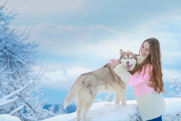 Foto mujer en un paseo invernal con un perro husky