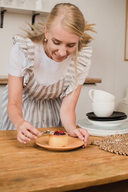 Mujer pastelera decora el postre. Concepto de cursos de confitería o cocina.