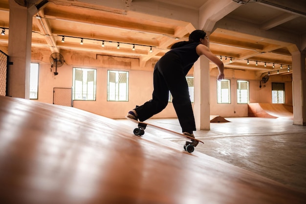 Mujer patinadora persona jugando patineta en el gimnasio deportivo joven mujer asiática es feliz y divertida con el estilo de vida de patinaje en la moda de moda femenina hipster adolescente de la ciudad