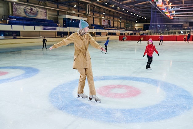 Mujer patinando sobre hielo en pista