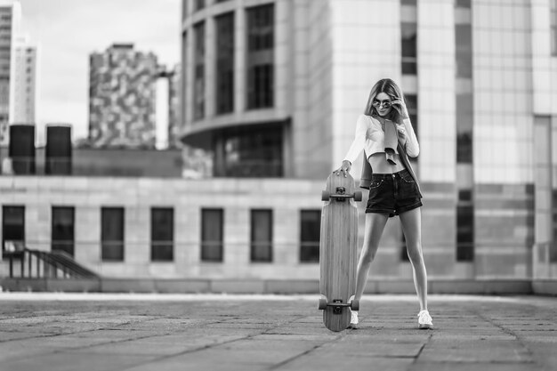 Mujer en una patineta en la ciudad hermosa foto en blanco y negro contrastante de una mujer montando