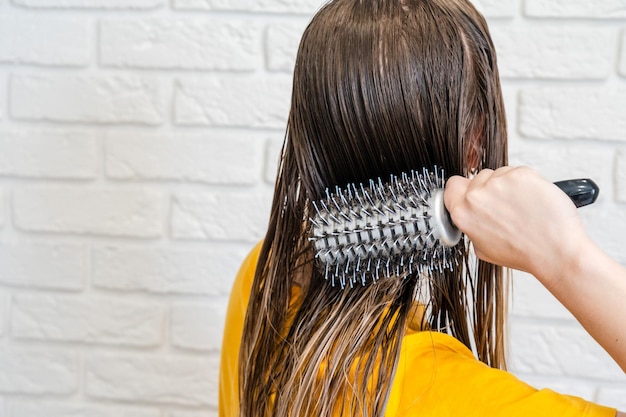 Mujer peina su cabello mojado