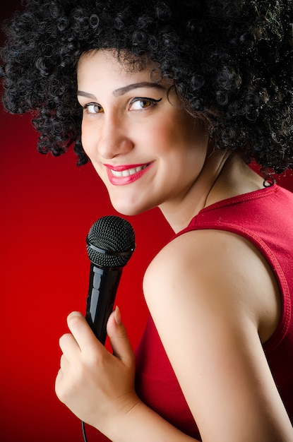 Mujer con peinado afro cantando en karaoke