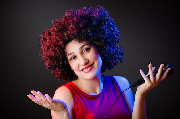 Mujer con peinado afro cantando en karaoke