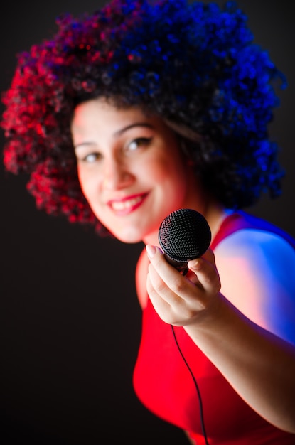 Mujer con peinado afro cantando en karaoke