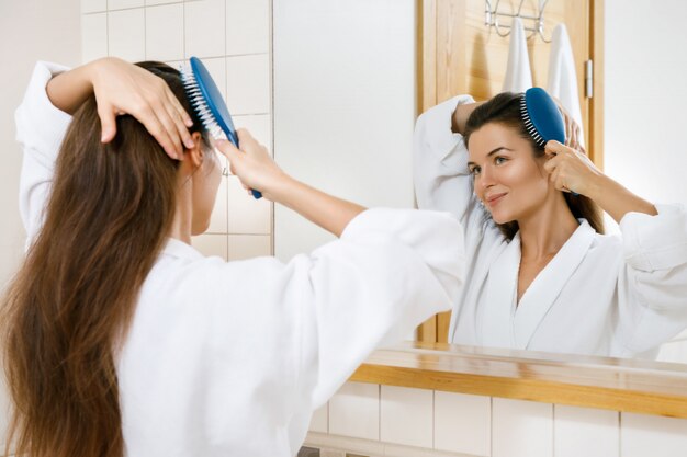 Mujer peinándose con un cepillo para el pelo