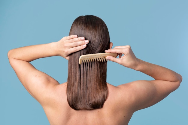 Mujer peinándose el pelo liso