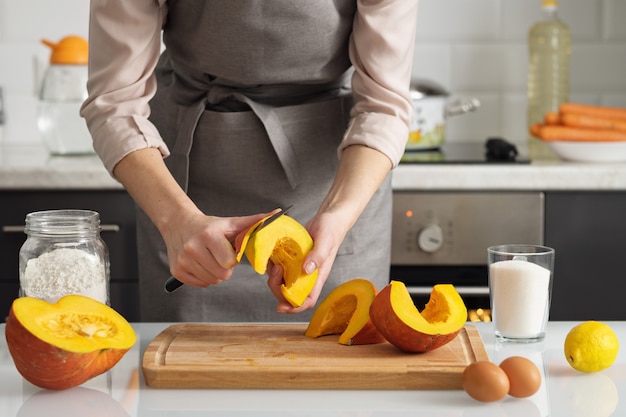 Una mujer pela una calabaza para hacer un pastel.