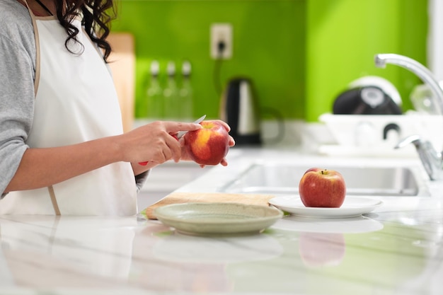 mujer pelando manzana roja