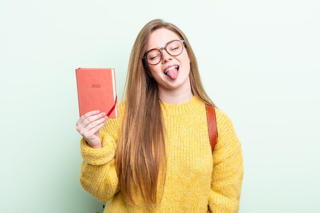 Mujer pelirroja con actitud alegre y rebelde, bromeando y sacando la lengua concepto de planificador