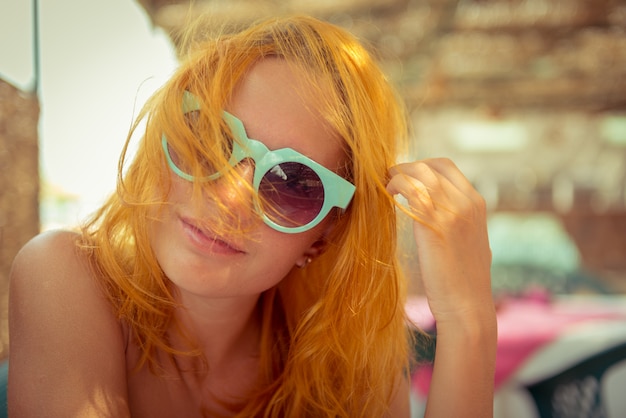 Mujer pelirroja en café de la playa