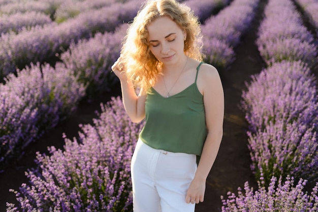 Una mujer pelirroja camina en un campo de lavanda en verano