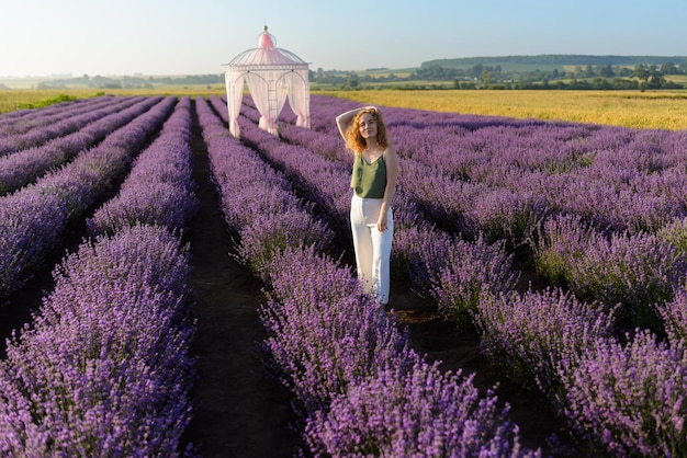 Mujer pelirroja en el campo de lavanda en la mañana de verano