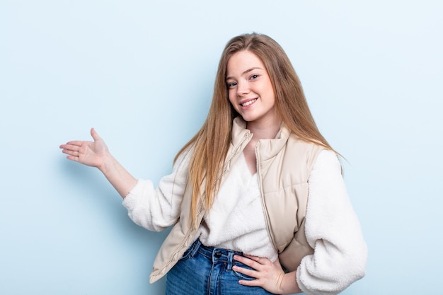 Mujer pelirroja caucásica que se siente feliz y alegre sonriendo y dándote la bienvenida invitándote a entrar con un gesto amistoso