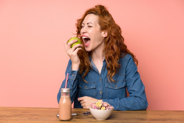 Mujer pelirroja desayunando