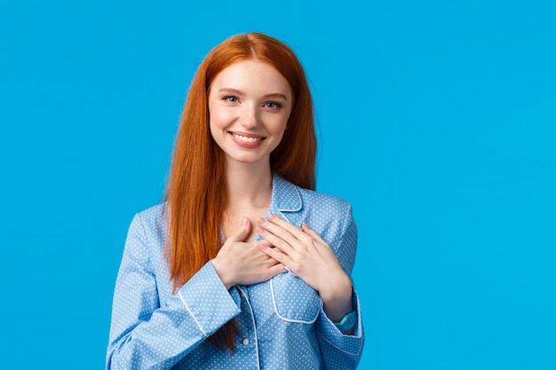 Mujer pelirroja encantadora y femenina con cabello largo y jengibre, vistiendo pijamas, agarrados de la mano