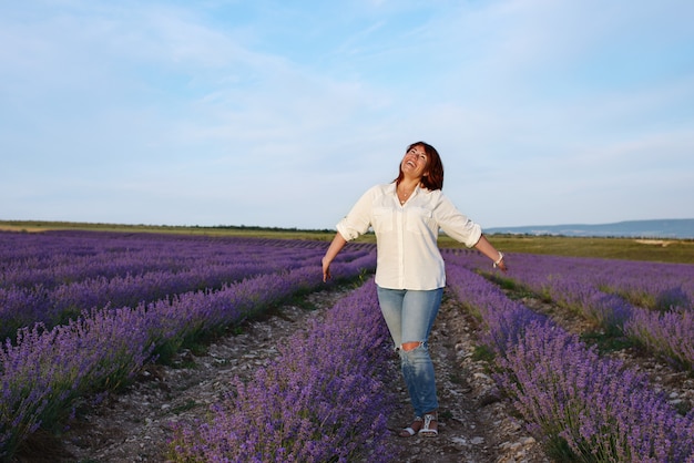 Mujer pelirroja feliz en el campo de lavanda