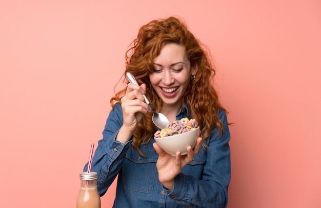 Foto mujer pelirroja feliz desayunando