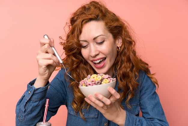 Foto mujer pelirroja feliz desayunando