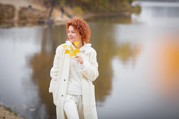 Mujer pelirroja feliz en ropa blanca