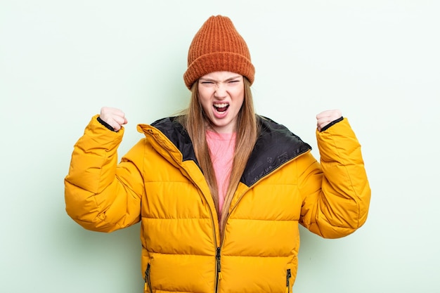 Mujer pelirroja gritando agresivamente con una expresión enojada. concepto de invierno