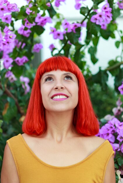 Mujer pelirroja con hermosas flores de fondo