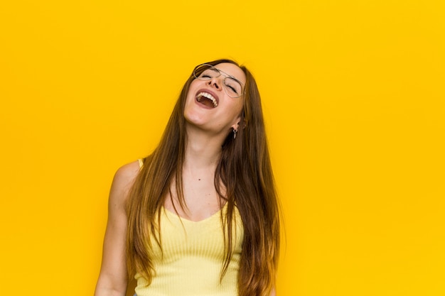 Mujer pelirroja jengibre joven con risa relajada y feliz pecosa, cuello estirado mostrando los dientes.