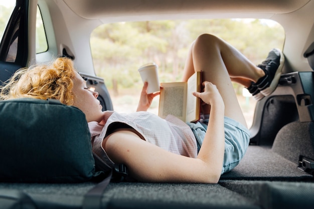 Foto mujer pelirroja joven tumbado en el coche